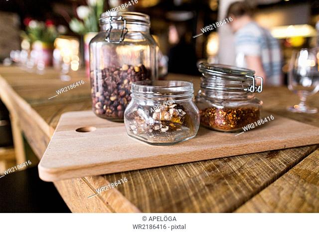 Close-up of nuts and chili flakes in jar on restaurant table