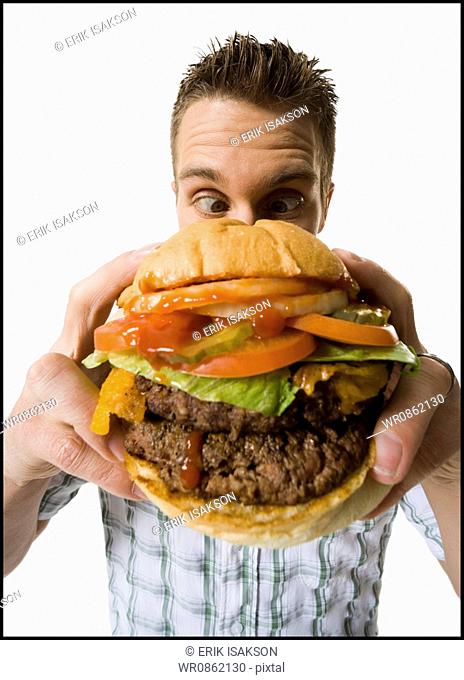 Close-up of a young man holding a hamburger