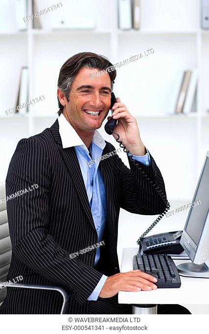 Attractive businessman making a phone call at work
