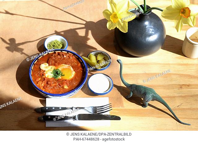 Shakshuka, a traditional Israeli egg dish, sits on a table with sides at Cafe Gordon in the district of Neukoelln in Berlin,  Germany, 01 April 2016