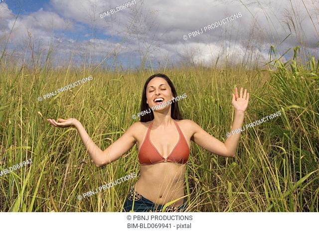 Hispanic woman smiling tall grass