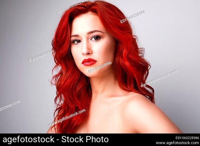 Portrait of sensual and attractive woman with beautiful red hair posing over white background. Space for text. High quality photo