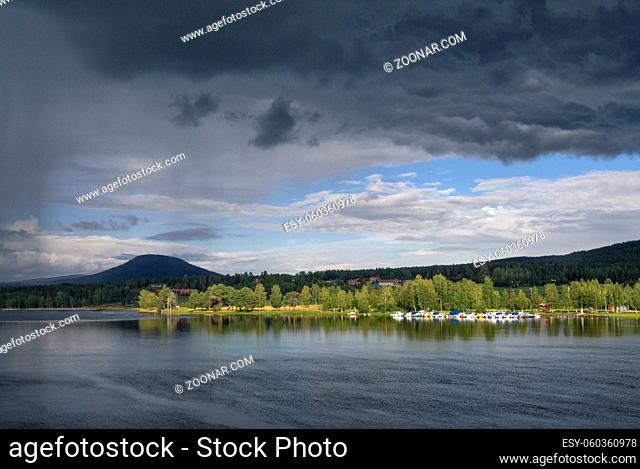 Dark clouds over the Ljusnan river close to the Swedish village Jarvso