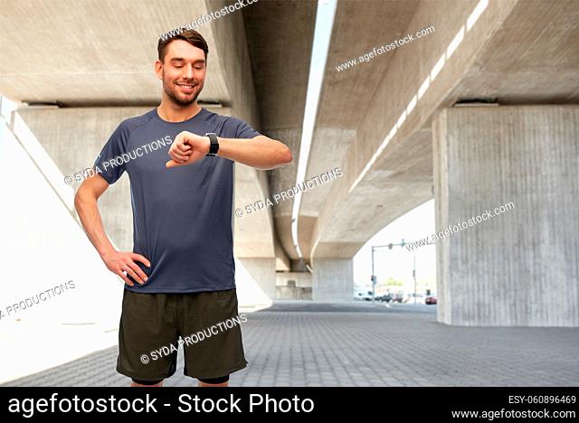 smiling man with smart watch or fitness tracker