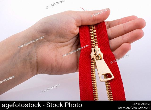Hand holding color zipper on a white background