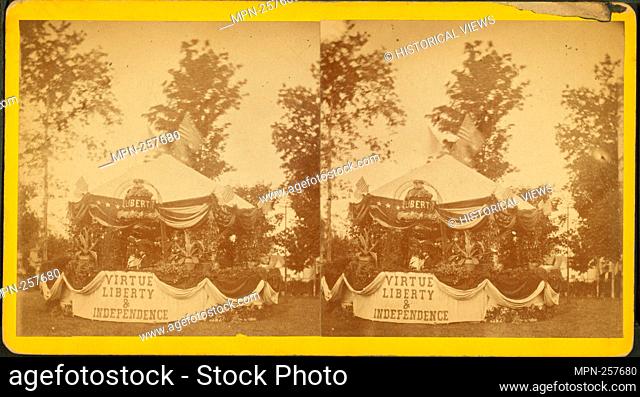 Decorated tent [Fourth of July?], with American flags, ornamental plants, liberty bell in flowers, and drapery bearing phrase 'Virtue Liberty & Independence;'...