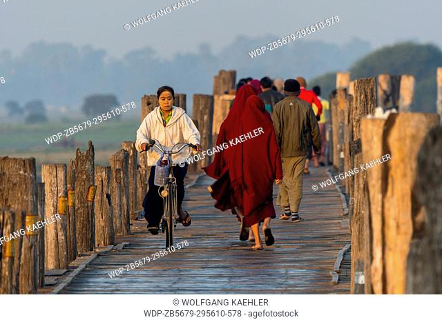 People on U Bein Bridge (built around 1850 and is believed to be the oldest and longest teakwood bridge in the world) spanning Taungthaman Lake near Amarapura
