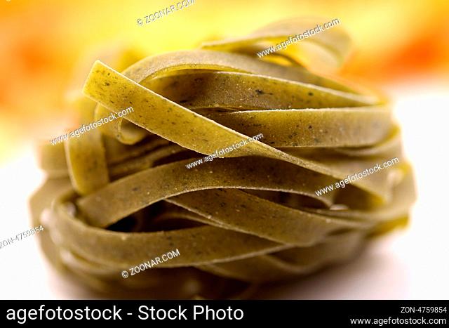 Tagliatelle paglia e fieno homemade tipycal italian pasta close-up on the white-yellow background