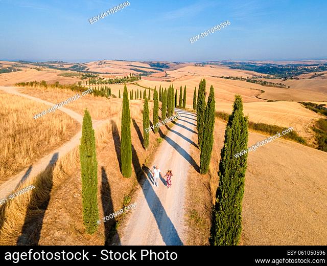 Tuscany, Crete Senesi rural sunset landscape. Countryside farm, cypresses trees, greenfield, sunlight and cloud. Italy, Europe