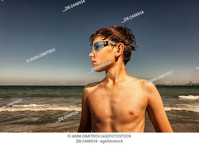 Boy wearing swimming googles at seaside