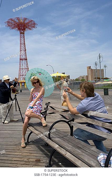 Young man and a senior man photographing a young woman and a senior woman, Parachute Drop, Coney Island, New York City, New York, USA