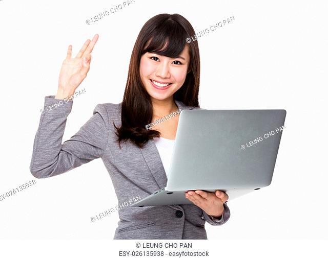 Businesswoman use of the notebook computer and ok sign gesture