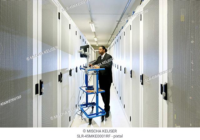 Businessman using computer with servers