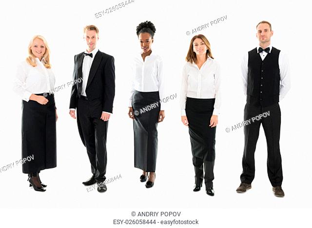 Full length portrait of confident multi ethnic restaurant staff standing against white background