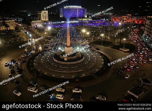 31 March 2021, Egypt, Cairo: A general view of the El-Tahrir Square with vehicles driving through the main roundabout adorned with the Obelisk of Ramses II and...