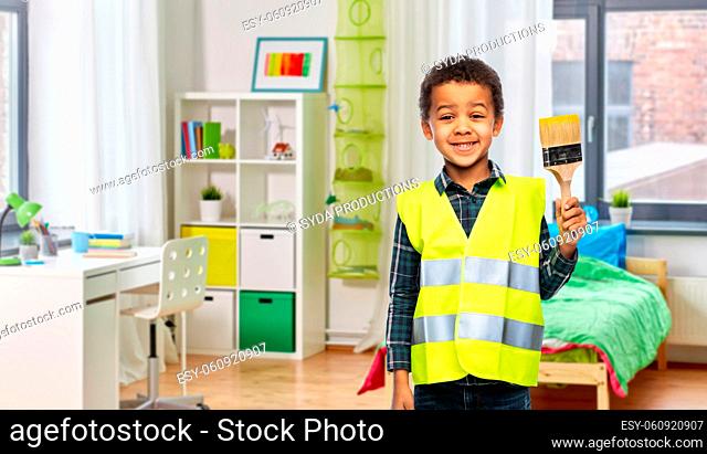 boy in safety vest with paint brush at home