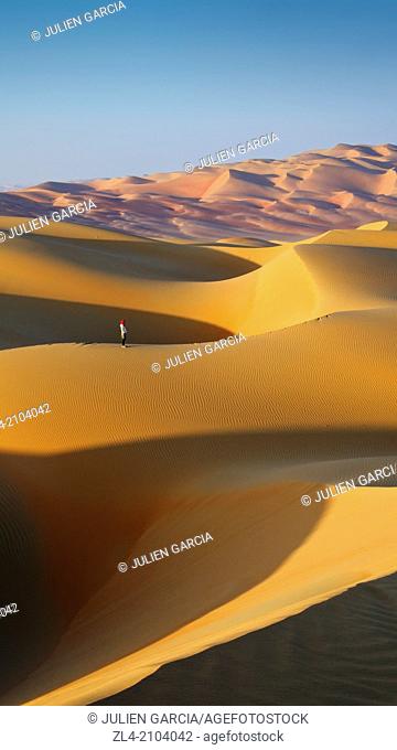 Woman in the sand dunes of the empty quarter desert. United Arab Emirates, UAE, Abu Dhabi, Liwa Oasis, Moreeb Hill, Tal Mireb. Model Released