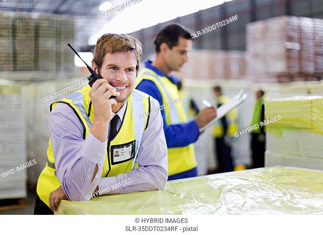 Worker using walkie talkie in warehouse