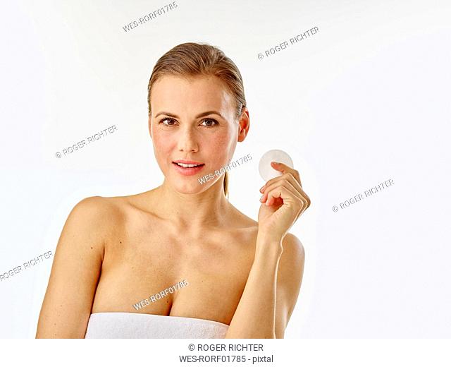 Young woman using cotton pad