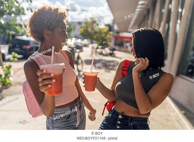 USA, Florida, Miami Beach, two carefree female friends having a soft drink in the city