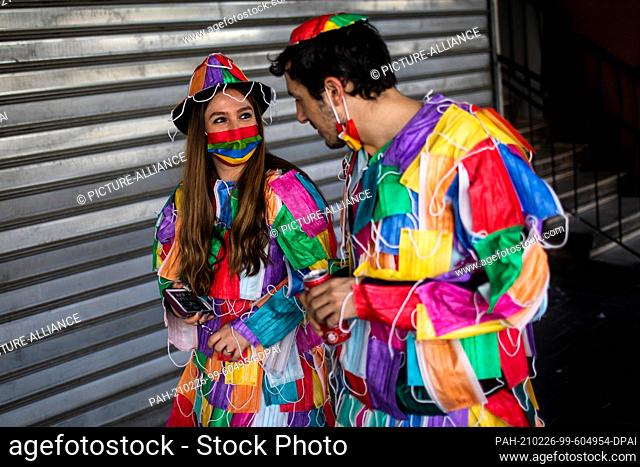 26 February 2021, Israel, Bnei Brak: A couple, wearing costumes made out of face masks, takes part in celebrations marking Purim