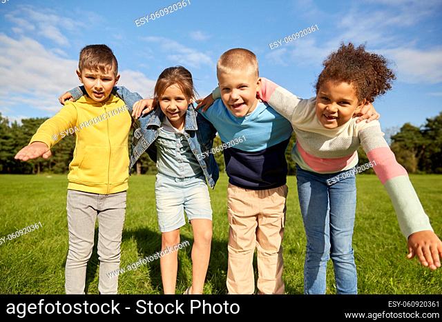 group of happy children hugging at park