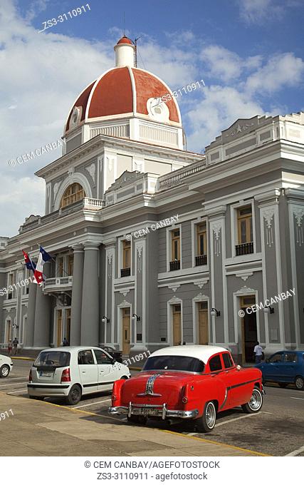 Old American car parked in front of the Goverment House-Palacio del Gobierno in Parque Jose Marti, Cienfuegos, Cuba, West Indies, Central America