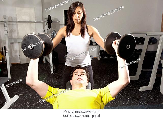 Man working with trainer at gym