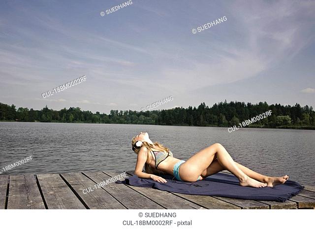 Young woman lying on blanket, relaxing