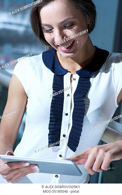 Businesswoman smiling and reading from tablet