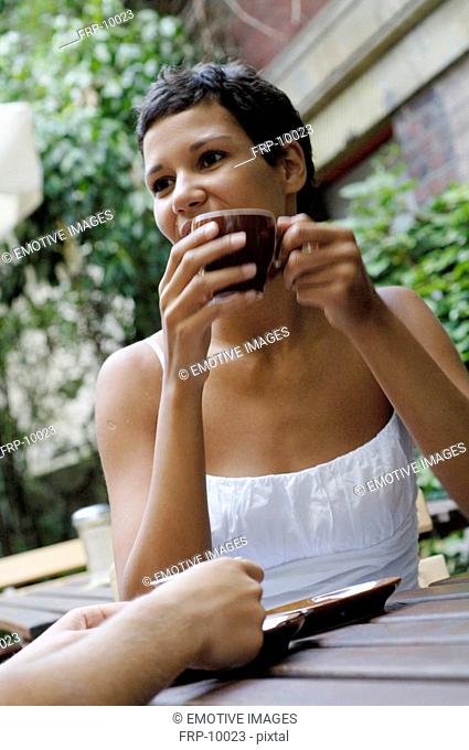 Young woman with cup of coffee outdoors