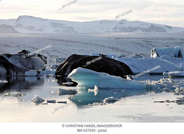 Icebergs, the darker ones coloured by volcanic ash, Joekulsarlon glacial lake, southern coast of Iceland, Atlantic Ocean