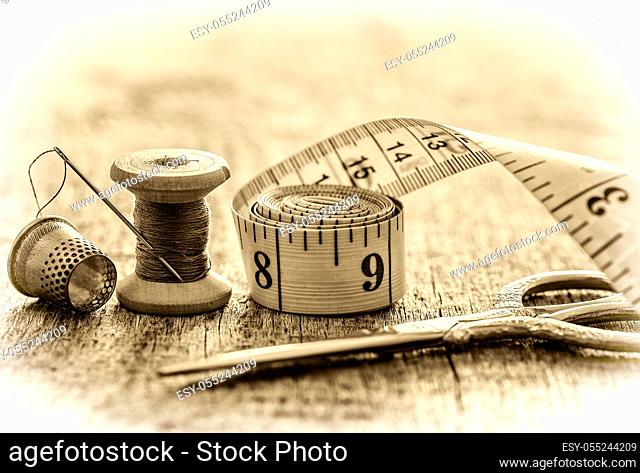 Creative image of tools and accessories for sewing on an old wooden surface. Concept. Selective focus. Retro style, black and white