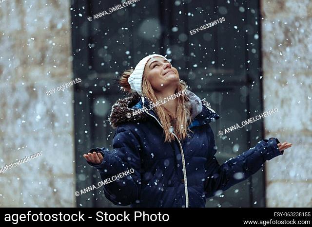 Snowfall. Happy Weekend on a Winter Holidays. Young woman having fun. Snow in the city