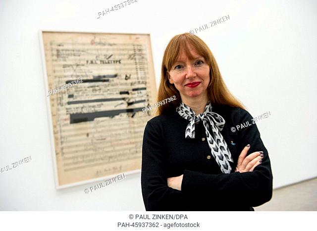 Artist Susan Philipsz stands at an over-sized sheet of music by composer Hanns Eisler that has been covered over with an FBI file at Hamburger Bahnhof in Berlin