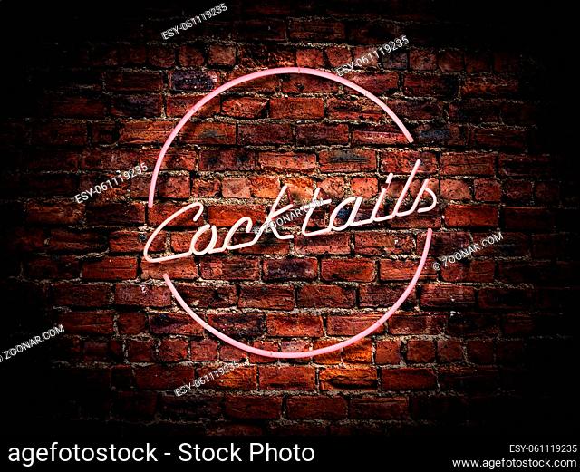 A Pink Neon Cocktails Sign Against A Red Brick Wall Outside A Bar Or Pub
