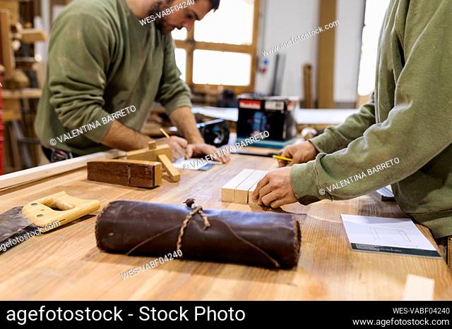Craftsmen working at table in workshop
