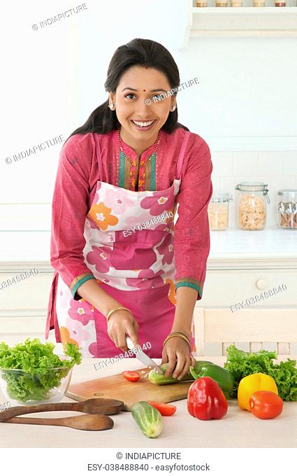 Woman cutting vegetable in kitchen
