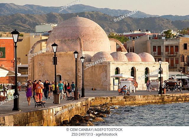 People and horse carriages in front of the Hassan Pasha Mosque at the Venetian harbor near the sea, Chania, Crete, Greek Islands; Greece, Europe