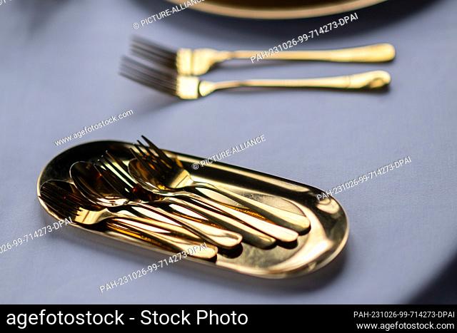 PRODUCTION - 26 October 2023, Saxony, Dresden: Gold colored cutlery lies on the table in a restaurant. Photo: Robert Michael/dpa