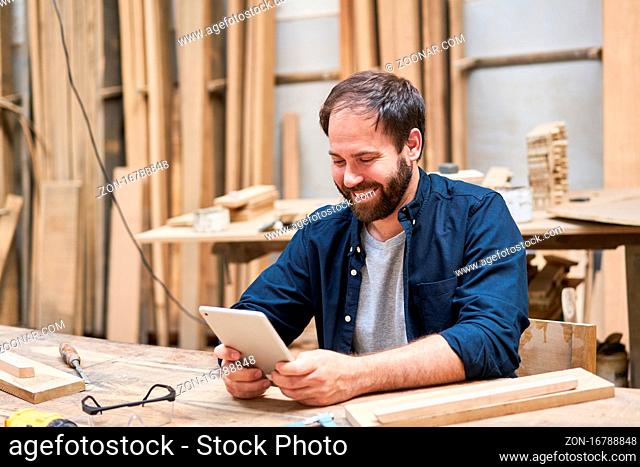 Handwerker mit Tablet Computer beim Videochat online in der Schreinerei Werkstatt