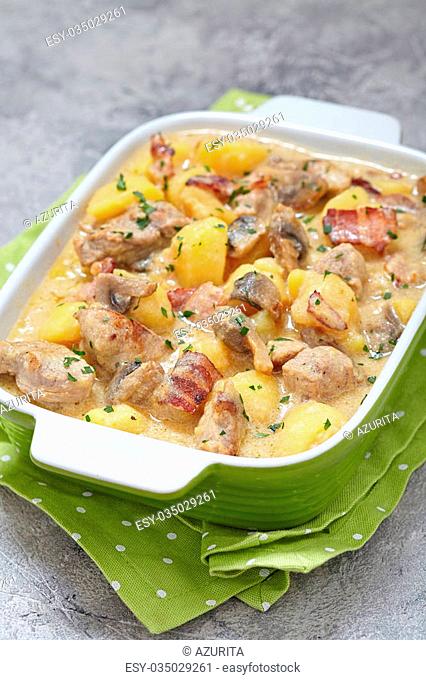Potato stew with pork, mushrooms and bacon in sour cream sauce