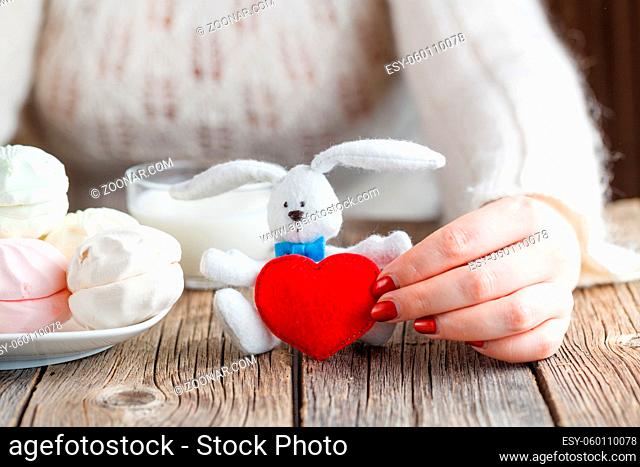 Woman offer red toy heart and eat sweets