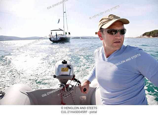 Man steering yacht dinghy