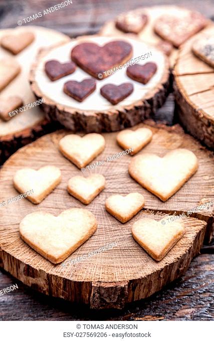 Delicious heart shaped cookies baked with love on wooden background