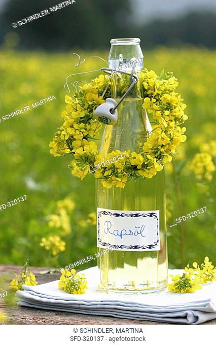 A bottle of rapeseed oil with small flower wreath