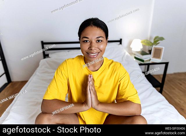 Woman practicing yoga sitting on the bed