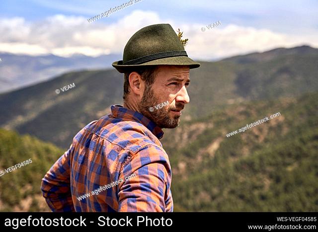Male mountaineer wearing hat looking away on sunny day