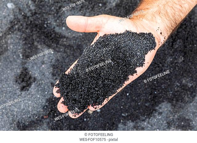 USA, Hawaii, Big Island, Hand holding black lava sand