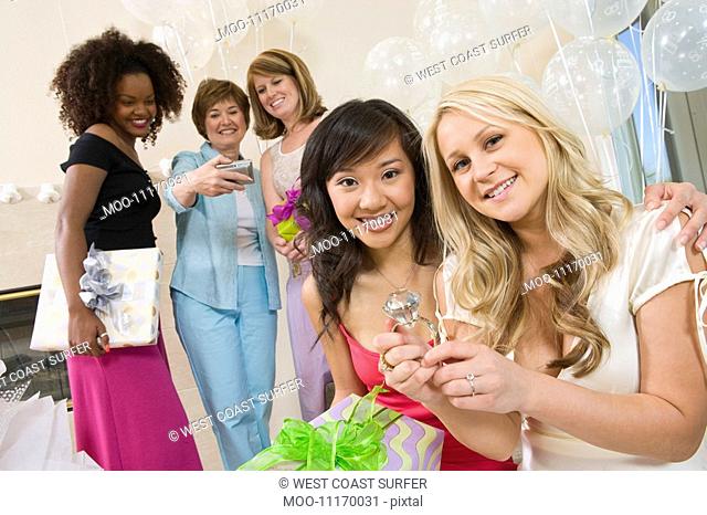 Bride sitting with her Friend showing large engagement ring at Bridal Shower